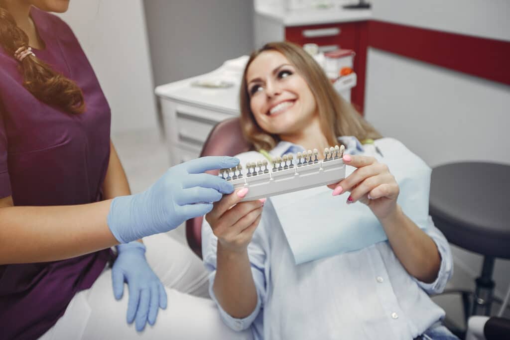 Beautiful lady in the dentist's office. Woman in a purple uniform
